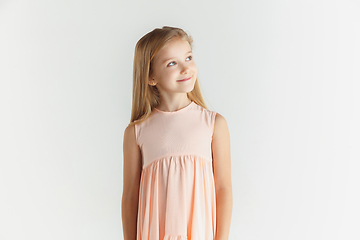 Image showing Little smiling girl posing in dress on white studio background