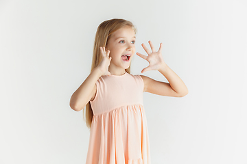 Image showing Little smiling girl posing in dress on white studio background