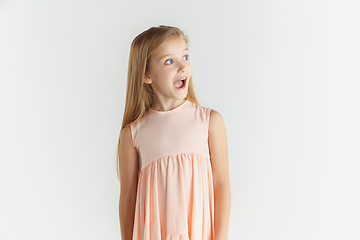 Image showing Little smiling girl posing in dress on white studio background