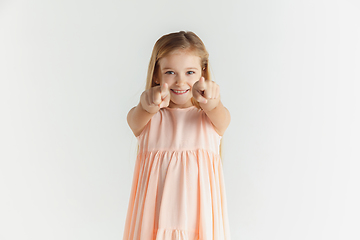 Image showing Little smiling girl posing in dress on white studio background