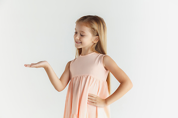 Image showing Little smiling girl posing in dress on white studio background