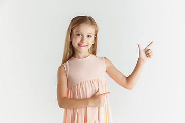 Image showing Little smiling girl posing in dress on white studio background