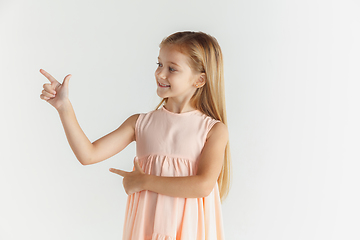 Image showing Little smiling girl posing in dress on white studio background