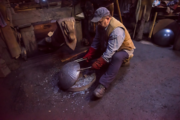 Image showing blacksmith workers using mechanical hammer at workshop