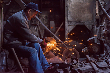 Image showing the blacksmith polishing metal products