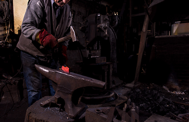 Image showing blacksmith manually forging the molten metal