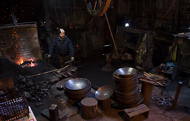 Image showing young traditional Blacksmith working with open fire