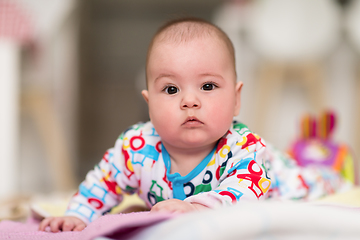 Image showing newborn baby boy playing on the floor