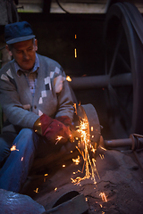 Image showing the blacksmith polishing metal products