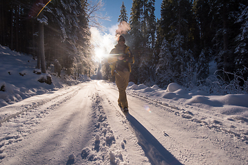 Image showing young photographer walking on snowy country road