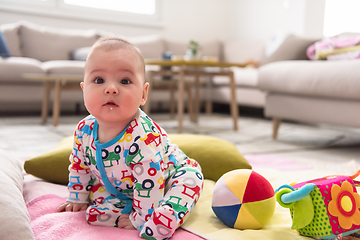 Image showing newborn baby boy sitting on colorful blankets