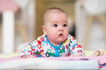 Image showing newborn baby boy playing on the floor