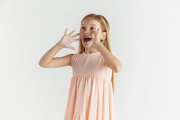 Image showing Little smiling girl posing in dress on white studio background