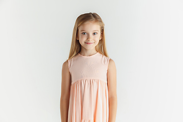 Image showing Little smiling girl posing in dress on white studio background