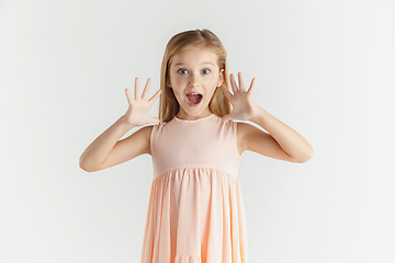 Image showing Little smiling girl posing in dress on white studio background