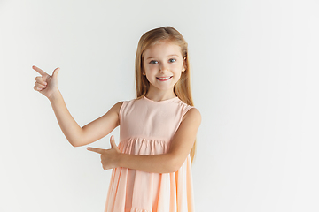 Image showing Little smiling girl posing in dress on white studio background