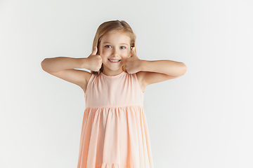 Image showing Little smiling girl posing in dress on white studio background