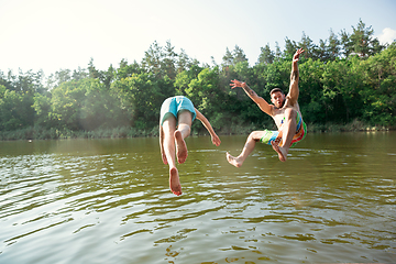 Image showing Happy friends having fun, ready to jump and swim in river