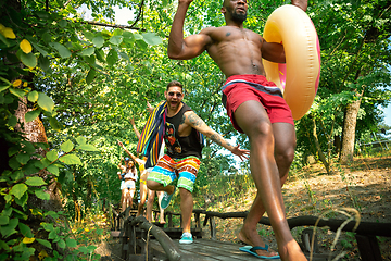 Image showing Group of happy friends having fun while running to swim on river