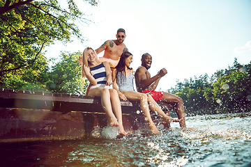 Image showing splashing water and laughting on the pier on river