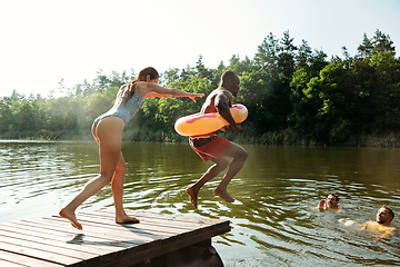 Image showing Happy friends having fun, jumping and swimming in river