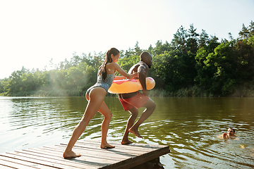 Image showing Happy friends having fun, jumping and swimming in river