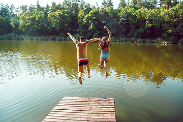 Image showing Happy friends having fun, jumping and swimming in river