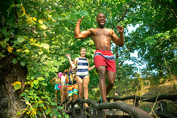 Image showing Group of happy friends having fun while running to swim on river