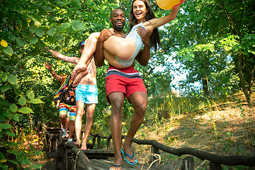 Image showing Group of happy friends having fun while running to swim on river