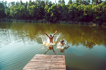 Image showing Happy friends having fun, jumping and swimming in river