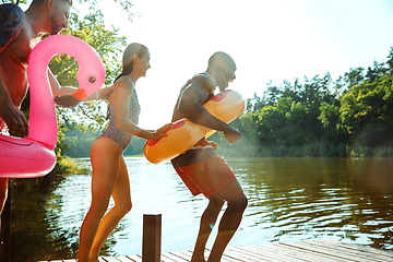 Image showing Happy friends having fun, jumping and swimming in river