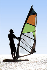 Image showing Silhouette of a windsurfer on waves of a bay