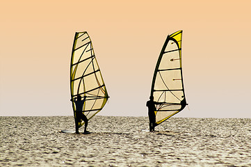 Image showing Silhouettes of two windsurfers on waves of a gulf 