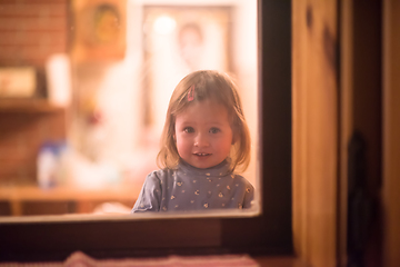 Image showing little cute girl playing near the window