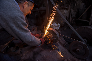 Image showing the blacksmith polishing metal products