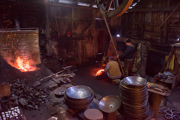 Image showing blacksmith workers using mechanical hammer at workshop