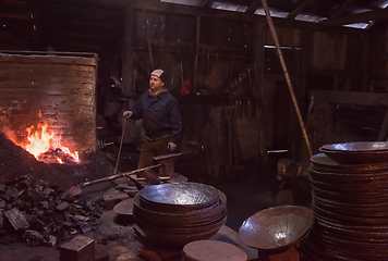 Image showing young traditional Blacksmith working with open fire