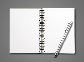 Image showing Blank open spiral notebook and pen isolated on dark grey