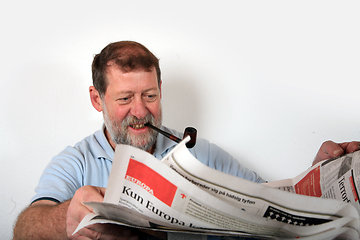 Image showing Mature scandinavian man smoking  pipe and reading news