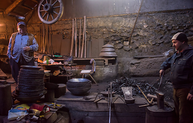 Image showing portrait of two generations traditional blacksmith