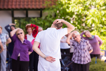 Image showing trainer training motivated active healthy senior people