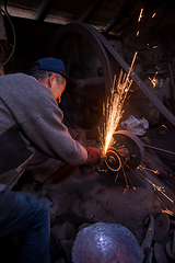 Image showing the blacksmith polishing metal products