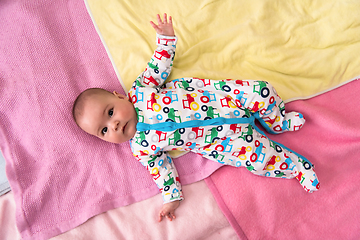 Image showing top view of newborn baby boy lying on colorful blankets
