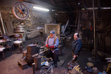 Image showing portrait of two generations traditional blacksmith