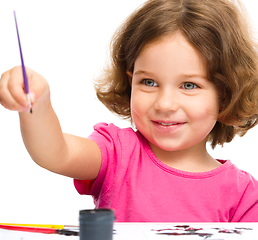 Image showing Little girl is painting with gouache