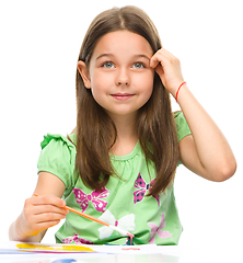 Image showing Little girl is painting with gouache