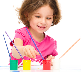 Image showing Little girl is painting with gouache