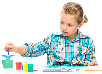 Image showing Little girl is painting with gouache