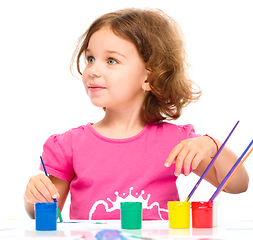 Image showing Little girl is painting with gouache