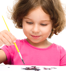 Image showing Little girl is painting with gouache